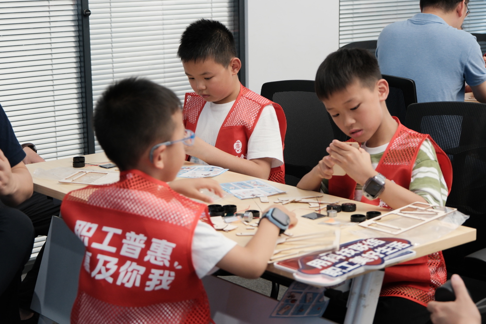 孩子们在家长陪伴下拼装木制汽车模型