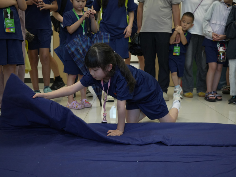 8月17日，四川成都，孩子在爸爸的宿舍学习叠被子。