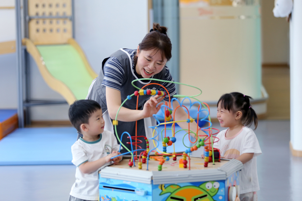 2026年9月2日，四川省乐山市市中区春华路西段一家婴幼儿托育中心，老师带领托育班的孩子一起玩绕珠游戏。 (2)