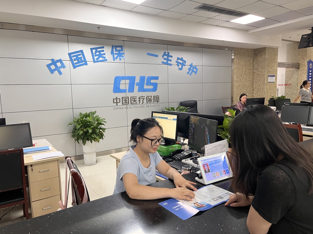 图，朝天区医疗保障局的工作人员正在为群众解答医保疑问
