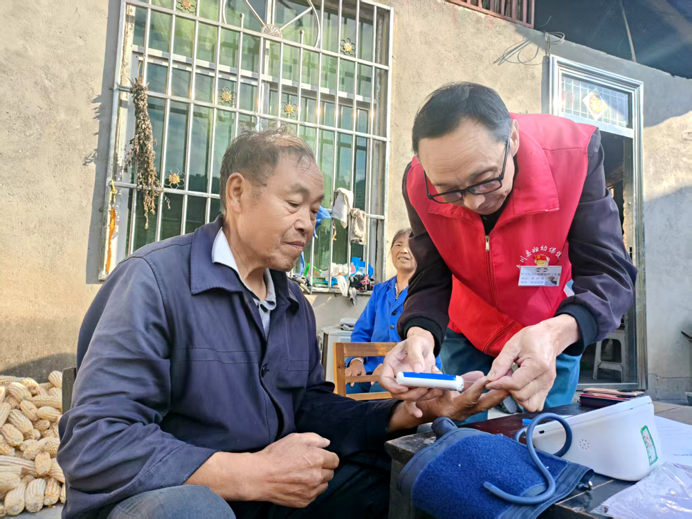 帮助村民测血压（图右 李开孝）