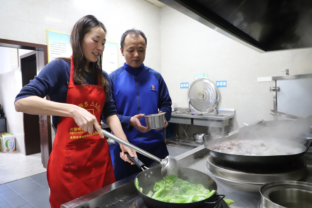 中秋节前夕，在西藏左贡，吴瀚与妻子在食堂后厨烹饪。(刘星文）