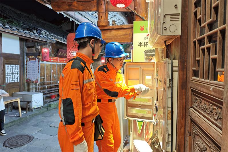 国网巴中市恩阳供电公司工作人员在恩阳古镇街巷，对沿街商铺配电设施开展用电隐患排查。（王松柏 摄）